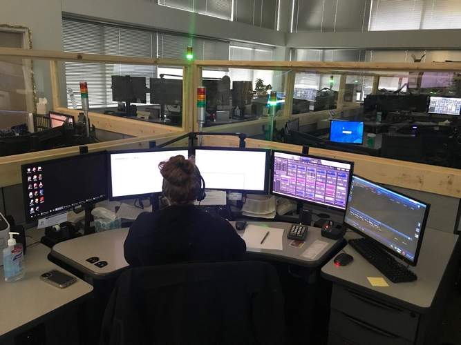 A man sitting at his desk with multiple monitors.