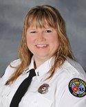 A woman in uniform smiling for the camera.